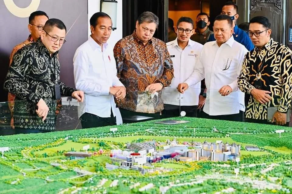 High-stakes review around a Pola Raya scale model.