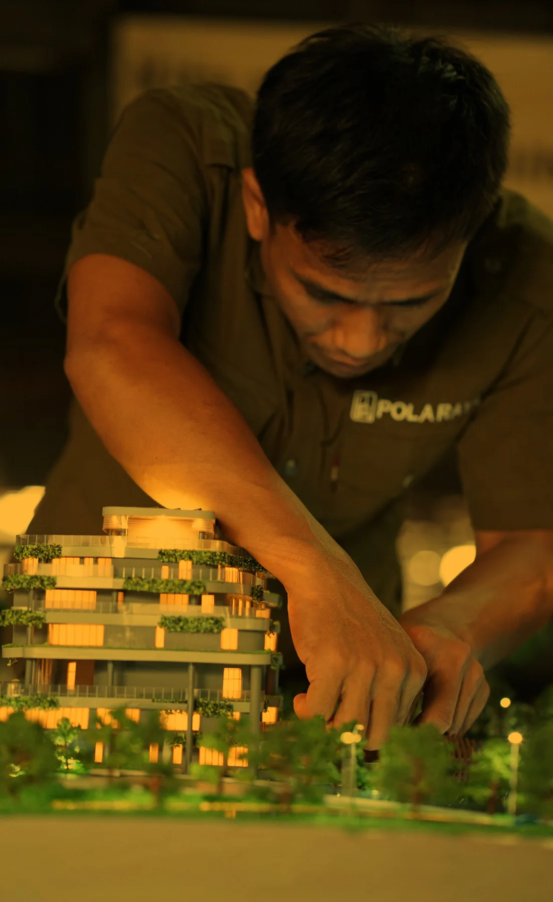 Pola Raya craftsman working on a lit model at night.