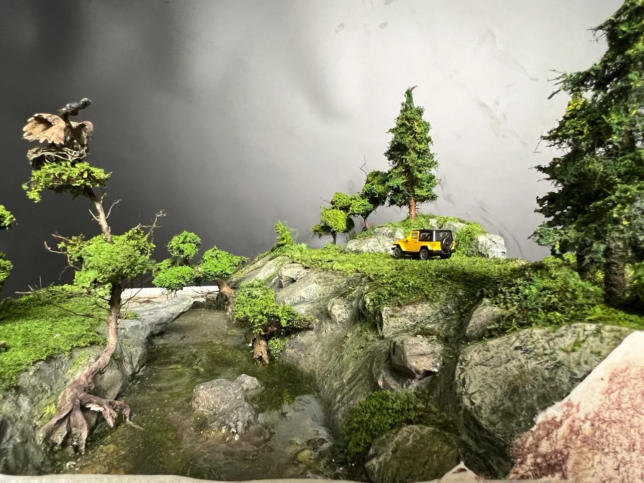 Bird detail inside a handcrafted miniature countryside scene.