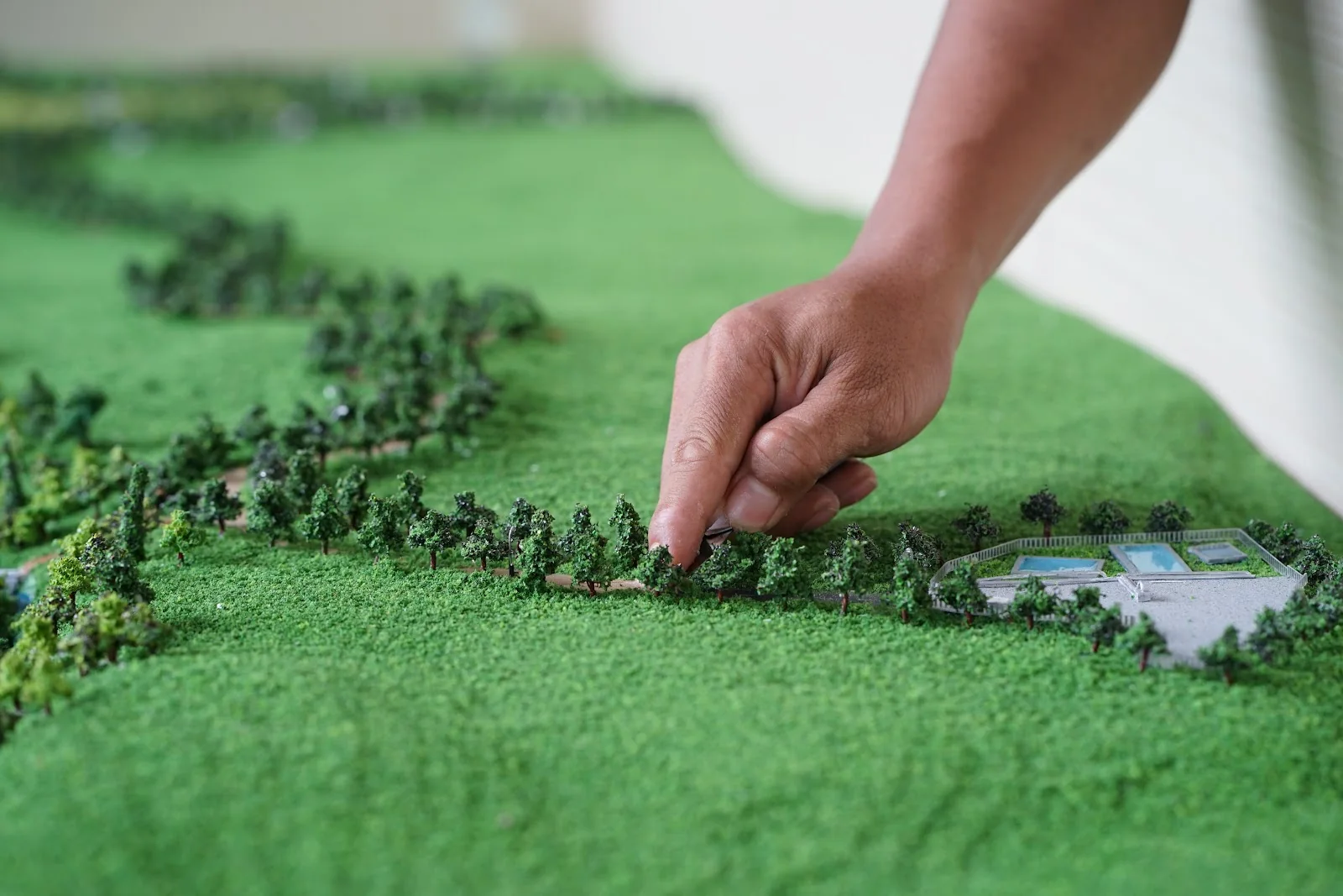 Hand placing trees into a detailed landscape model.